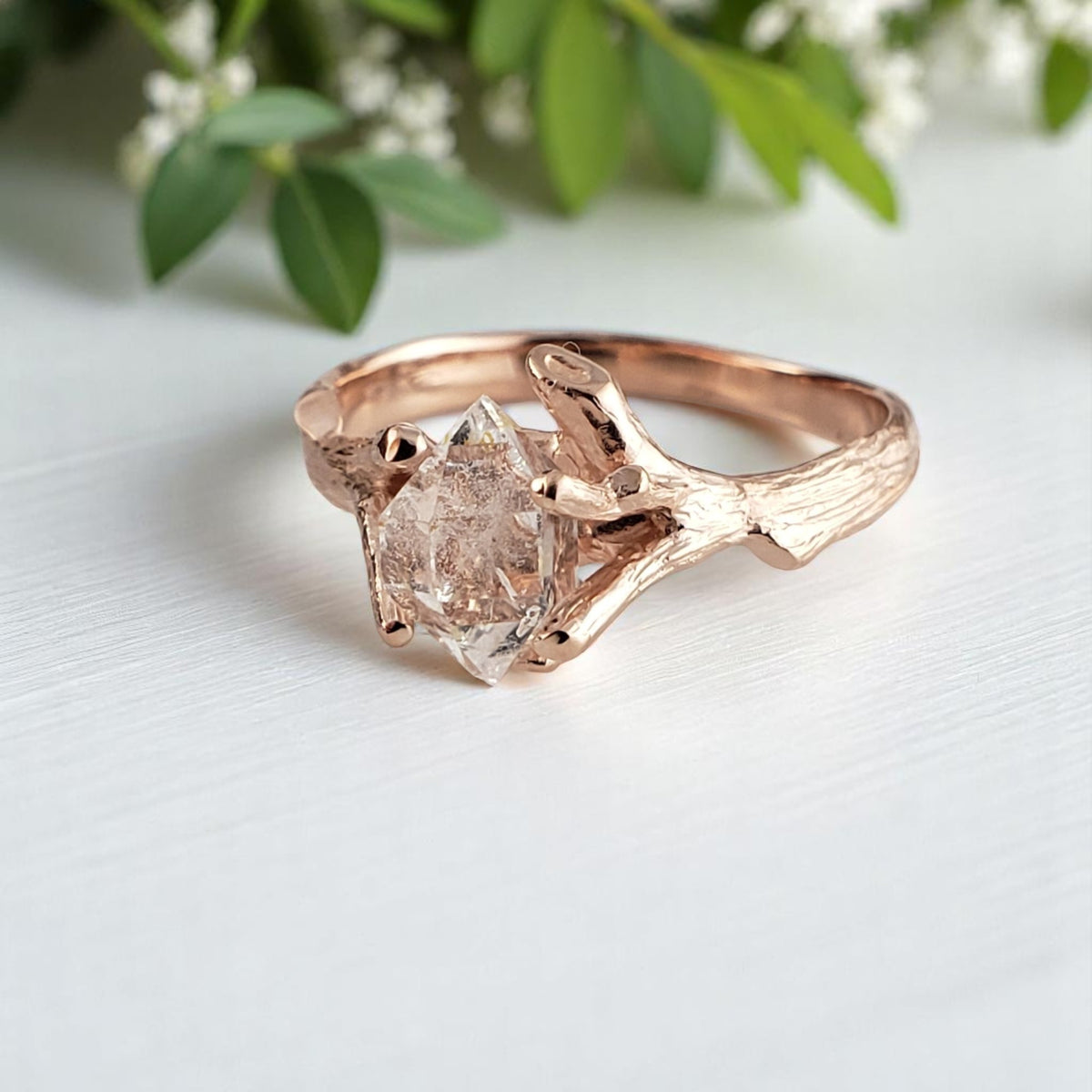 Rose gold ring with a large diamond on a light background