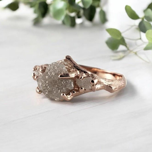 Rose gold ring with a raw rough diamond on a light background