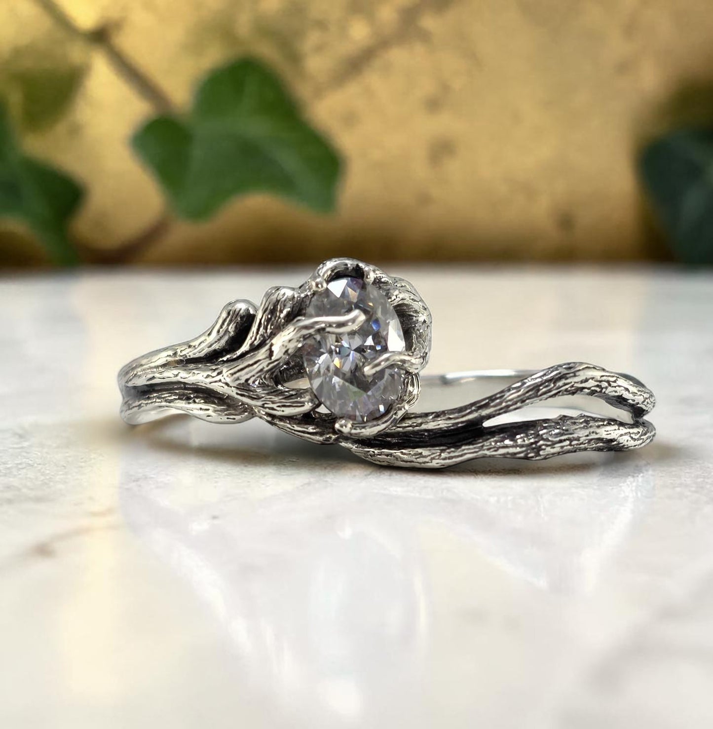 oval moissanite lab made diamond in a white gold vine setting
